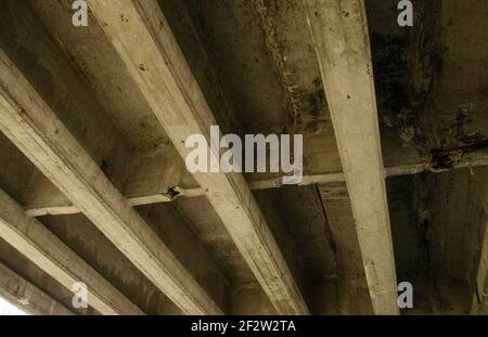 Stahlbetonkonstruktion der Autobahn-Überführung. Ansicht Von Unten Nach Unten. Risse von Betonbalken unter der Brücke. Unter der Überführung der Zement Stockfoto