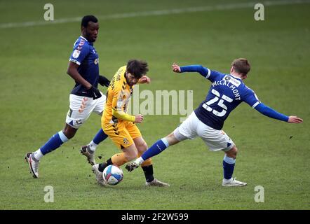 Wes Hoolahan (Mitte) von Cambridge United und Alfie McCalmont von Oldham Athletic kämpfen im zweiten Spiel der Sky Bet League im Boundary Park in Oldham um den Ball. Stockfoto