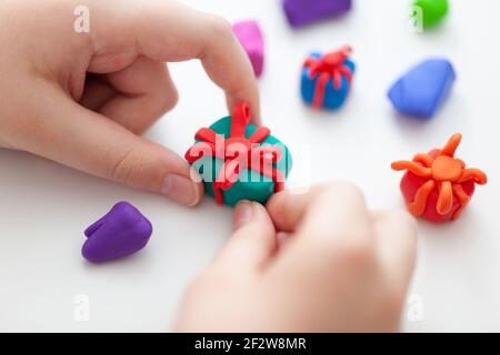 Ein kleiner Junge, der Fimo-Geschenkschachteln macht. Geringe Schärfentiefe. Nahaufnahme. Stockfoto