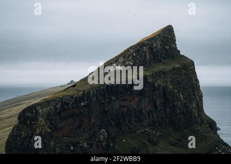 Panoramablick auf die wunderschöne Landschaft in Mykines, mit Fokus auf eine Papageientaucher-Familie, Färöer-Inseln Stockfoto