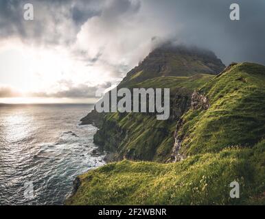 Färöer-Inseln mit stürmischer Sicht auf mykines und den atlantik auf der Insel Vagar vom Mulafossur-Wasserfall aus gesehen. Niedrige Wolken mit atlantik Stockfoto