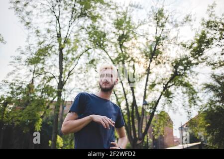 Ein Porträt eines kaukasischen blonden Mannes mit einer Zigarette Auf einem Naturhintergrund Stockfoto