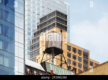 Wasserturm zwischen modernen Gebäuden in Manhattan, New York City, USA. Stockfoto