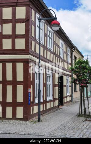 Schön renoviertes Fachwerkhaus. Im Vordergrund eine ungewöhnliche Straßenlampe und ein blühender Kirschbaum Stockfoto