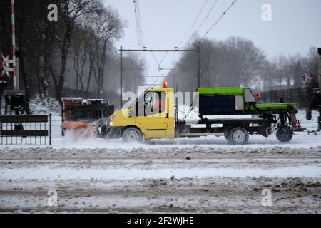 Amersfoort, Niederlande, Feb,7,2021:Schneepflug-LKW entfernt schmutzigen Schnee und streuen Salz gegen Schlupf auf Radweg auf einer Eisenbahn, Ebene Stockfoto