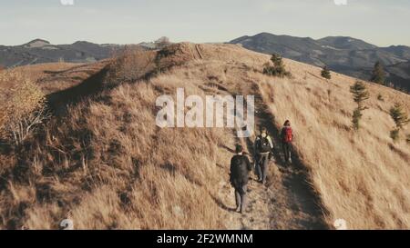 Zeitlupe Nahaufnahme Reisende Wandern auf Berg verbrannt Gras Antenne. Unglaubliche Herbstnatur Stockfoto