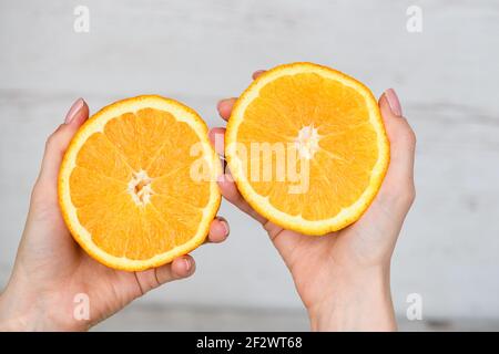 Frau bereiten frischen Zitrusfruchtsaft aus zwei abgeschnittenen Hälften der Orange zu quetschen, gesunde hausgemachte Getränk, Draufsicht Stockfoto