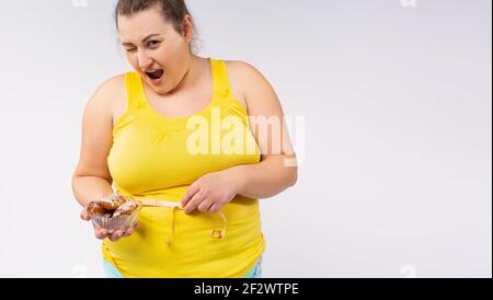 Banner, Langformat. Eine blinkende Plus-Size-Frau in einem hellen T-Shirt mit einem Zentimeter und einem Picenie schaut auf die Kamera. Seitenraum. Stockfoto
