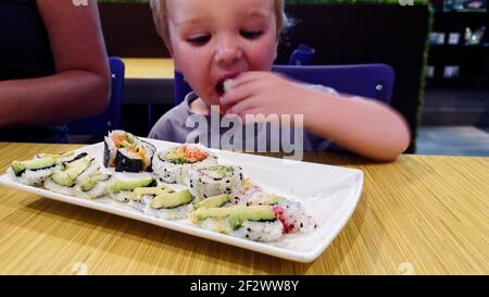 Ein kleiner Junge (2 Jahre) Sushi essen in einem Restaurant Stockfoto