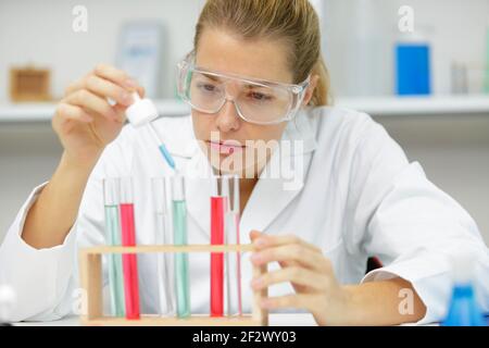 Junge Frau Techniker verwendet eine Pipette in einem chemischen Labor Stockfoto