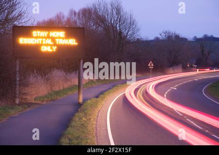 „Bleib zu Hause, nur auf Reisen“. Elektronische Punktmatrixanzeige mit Hinweisschild zur Einhaltung der Vorschriften zur Pandemiesperre Covid 19. England, Großbritannien. Stockfoto