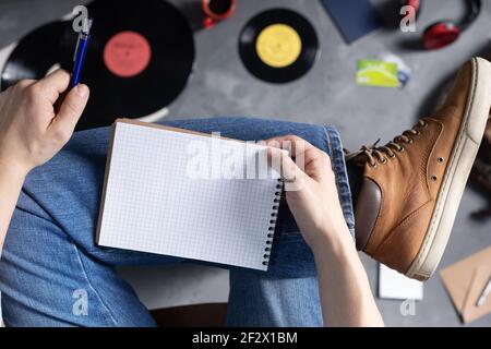 Männer Hand halten Stift oder Bleistift und Notizbuch und Bein in Jeans. Studium oder Kunst Musik Lifestyle Konzept Stockfoto