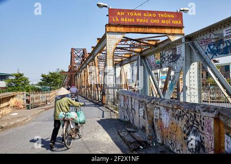 Long Bien Bridge über den Roten Fluss, Hanoi, Vietnam. Fahrrad- und Fußverkehr sind auf beiden Seiten der Bahn erlaubt. Stockfoto