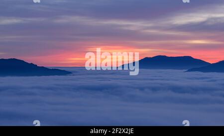 Sonnenaufgang mit einem Meer von Wolken über dem Sau Reservoir vom Gipfel Roca del Migdia aus gesehen (Collsacabra, Katalonien, Spanien) Stockfoto