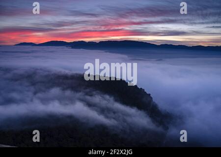 Sonnenaufgang mit einem Meer von Wolken über dem Sau Reservoir vom Gipfel Roca del Migdia aus gesehen (Collsacabra, Katalonien, Spanien) Stockfoto