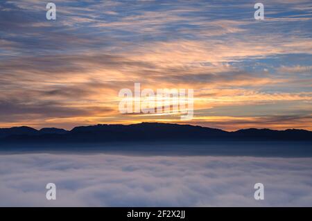 Sonnenaufgang mit einem Meer von Wolken über dem Sau Reservoir vom Gipfel Roca del Migdia aus gesehen (Collsacabra, Katalonien, Spanien) Stockfoto