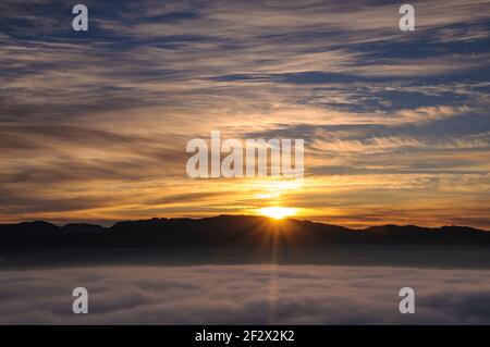 Sonnenaufgang mit einem Meer von Wolken über dem Sau Reservoir vom Gipfel Roca del Migdia aus gesehen (Collsacabra, Katalonien, Spanien) Stockfoto