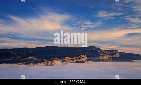 Sonnenaufgang mit einem Meer von Wolken über dem Sau Stausee. Panoramablick auf die Tavartet-Klippen vom Gipfel Roca del Migdia (Collsacabra, Katalonien) Stockfoto