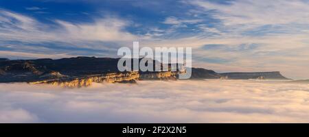 Sonnenaufgang mit einem Meer von Wolken über dem Sau Stausee. Panoramablick auf die Tavartet-Klippen vom Gipfel Roca del Migdia (Collsacabra, Katalonien) Stockfoto