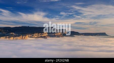 Sonnenaufgang mit einem Meer von Wolken über dem Sau Stausee. Panoramablick auf die Tavartet-Klippen vom Gipfel Roca del Migdia (Collsacabra, Katalonien) Stockfoto