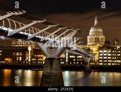 Eine Nachtaufnahme der St. Paul’s Cathedral und des Millennium Brücke beleuchtet und Reflexionen auf der Themse Stockfoto