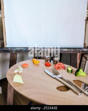 Künstler Holzpalette, auf der Gemüse platziert werden. In den Tassen gibt es Gemüse Dip. Ein Messer und eine Gabel. Arbeitsfläche im Hintergrund für den Kopierbereich. Stockfoto