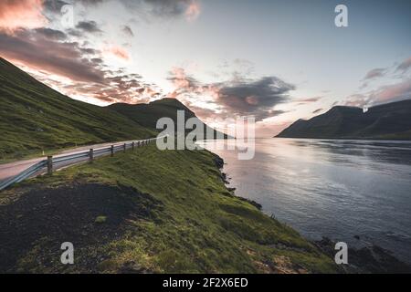 Färöer-Inseln Kalsoy im Sonnenuntergang Licht durig Dämmerung mit rosa Himmel und Klippen. Stockfoto