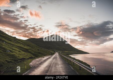 Färöer-Inseln Kalsoy im Sonnenuntergang Licht durig Dämmerung mit rosa Himmel und Klippen. Stockfoto