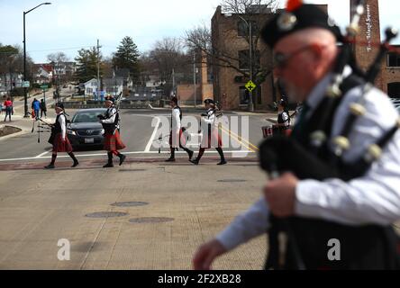 St. Charles, Illinois, USA. März 2021, 13th. Samstag, 13. März 2021 - St. Charles, Illinois USA - Mitglieder der Chicago Highlanders Pipe Band machen sich auf den Weg in die Innenstadt von St. Charles, Illinois, um für Käufer aufzutreten. Die Coronavirus-Pandemie zwang Stadtbeamte, die Parade zum St. Patrick's Day 2021 abzusagen. Kredit: H. Rick Bamman/ZUMA Wire/Alamy Live Nachrichten Stockfoto