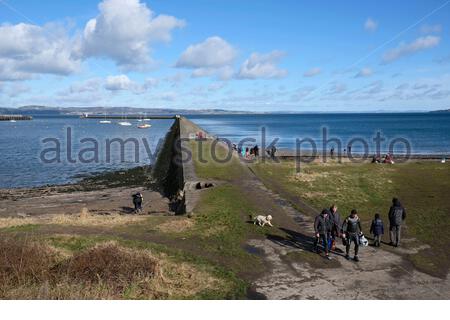 Menschen genießen Granton Hafen Wellenbrecher und Wardie Bay an einem sonnigen Tag, Edinburgh, Schottland Stockfoto