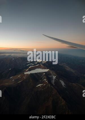 Panoramablick auf den Sonnenuntergang in den schneebedeckten anden mit dem Flugzeug Flügel aus Flugzeug Fenster Sitz Landung in Santiago de Chile Südamerika Stockfoto