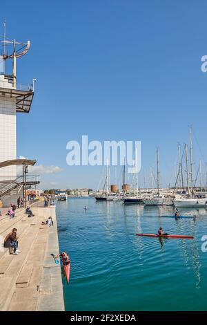 Kajakfahrer aus dem echten Club nautico segeln in ihren roten Kanus durch die Gewässer des Grao de Castellon, mit den Yachten im Hintergrund, Spanien Stockfoto