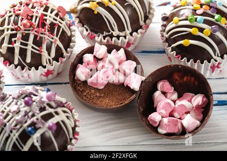 Kakaobomben sind schwarze Schokoladenschalen, die mit Kakaopulver gefüllt sind Und Marshmallows Stockfoto