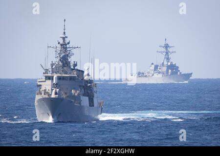 Die griechische Marine Hydra-Klasse Fregatte HS Psaraa, links, und die US Navy Arleigh-Burke Klasse Lenkraketen Zerstörer USS Thomas Hudner durchreist das Mittelmeer in Formation mit der Eisenhower Carrier Strike Group 12. März 2021 im Mittelmeer. Stockfoto