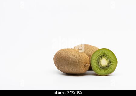 Kiwi-Früchte isoliert auf weißem Hintergrund, zwei ganze Kiwi-Früchte und eine halbe Kiwi-Frucht isoliert Stockfoto