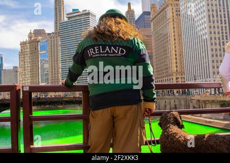 Chicago, IL, USA. März 2021, 13th. Ein Mann schaut auf den Chicago River, nachdem die Stadt ihn heimlich grün gefärbt hat, um mit der Tradition der Stadt bei der Ehrung des irisch-amerikanischen Erbes der Stadt zu bleiben. Kredit: Dominic Gwinn/ZUMA Wire/Alamy Live Nachrichten Stockfoto