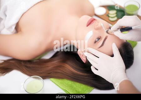 Hardware Kosmetologie. Closeup Bild der reizende junge Frau mit Creme Maske in einem Schönheitssalon. Stockfoto