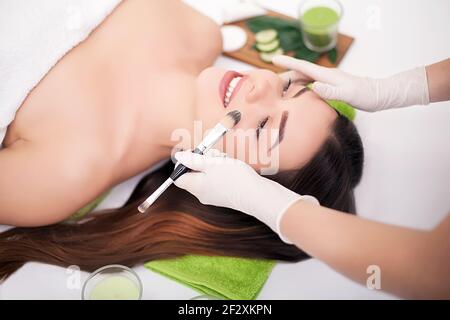 Hardware Kosmetologie. Closeup Bild der reizende junge Frau mit Creme Maske in einem Schönheitssalon. Stockfoto