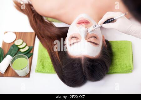 Hardware Kosmetologie. Closeup Bild der reizende junge Frau mit Creme Maske in einem Schönheitssalon. Stockfoto