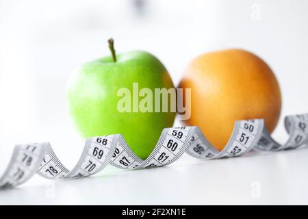 Diät. Fitness und gesunde Ernährung Konzept. Ausgewogene Ernährung mit Gemüse. Frische, grüne Gemüse, Maßband auf weißem Hintergrund. Nahaufnahme Stockfoto