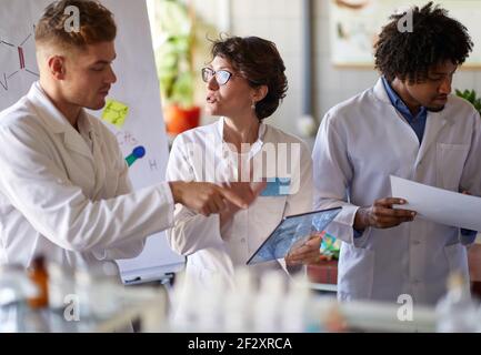 Team von jungen Labortechnikern diskutieren Testergebnisse in der Labor Stockfoto