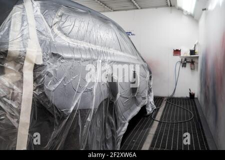 Moderne Automobil mit Kunststoff für Malerei und vorbereitet abgedeckt Parken im Reparaturzentrum Stockfoto