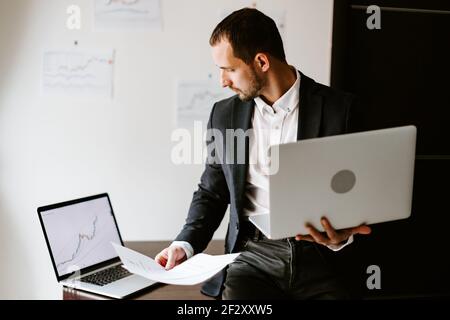Konzentrierter Geschäftsmann, der im Büro am Laptop arbeitet Stockfoto