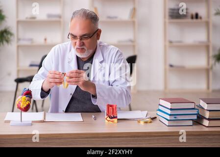 Alte Zahnarztlehrerin sitzt im Klassenzimmer Stockfoto
