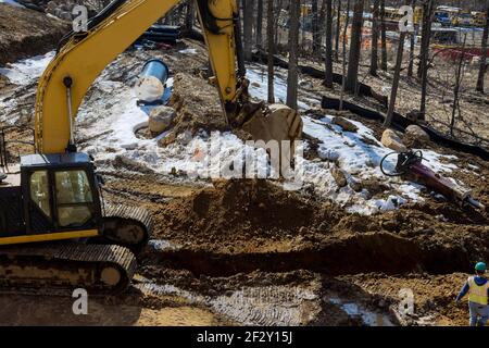 Bagger graben einen riesigen Graben, Graben für Entwässerung Kanal Versorgungsleitung Rohrleitung Installation auf Baustelle. Stockfoto