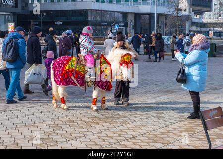 Minsk, Weißrussland - 13. März 2021: Kleines Mädchen auf einem Pony. Die Straßenfeste Masleniza im Stadtzentrum von Minsk, Weißrussland Stockfoto