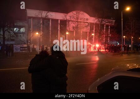 Warschau, Warschau, Polen. März 2021, 13th. Ein Paar umarmt und schaut nach Warschau Legia-Fans vor dem Legia-Stadion, das wegen der Sperre am 13. März 2021 in Warschau, Polen, für die Öffentlichkeit geschlossen wurde. Rund tausend Fans der Warschauer Legia-Fußballmannschaft nahmen an einer regierungsfeindlichen Demonstration gegen die Beschränkungen des Covid-19 unter dem Motto "Offene Stadien" Teil und forderten mindestens 50 Prozent der verfügbaren Plätze während der Spiele. Quelle: Aleksander Kalka/ZUMA Wire/Alamy Live News Stockfoto