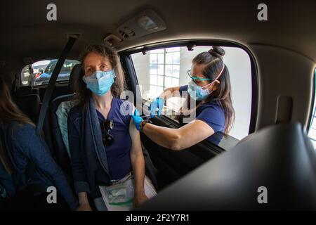 Eine Frau erhält einen Covid-19-Schuss auf einer Sutter Health-Fahrt durch die Impfstelle in Santa Cruz, Kalifornien. März 2021 Stockfoto