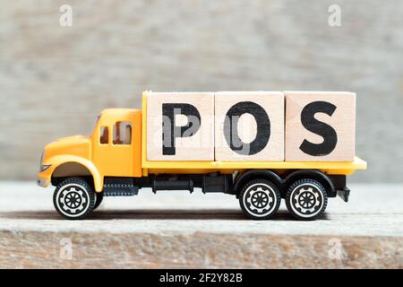 Spielzeug-LKW halten Alphabet Buchstaben Block im Wort POS (Abkürzung für Point of Sale) auf Holzhintergrund Stockfoto