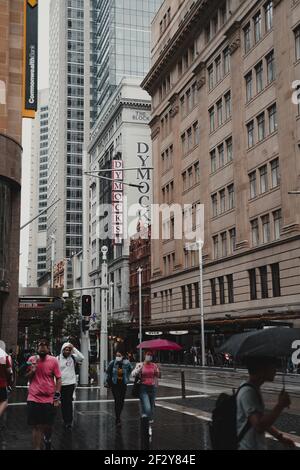Fußgänger überqueren die Market Street entlang der George Street an einem regnerischen Tag im zentralen Geschäftsviertel von Sydney. Stockfoto